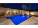 Backyard pool with tiled surround and brick perimeter wall, illuminated landscaping, and water feature wall at 31311 N 138Th Ave, Peoria, AZ 85383