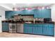 Bright kitchen featuring vintage blue cabinets, stainless steel appliances, and tile flooring at 3351 N 6Th Ave, Phoenix, AZ 85013