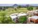 An aerial view of modern condos overlooking a lush green golf course with a stunning mountain backdrop at 3500 N Hayden Rd # 801, Scottsdale, AZ 85251