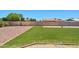 Lush backyard with artificial turf, desert landscaping, and a stone fire pit area at 3747 W Aire Libre Ave, Phoenix, AZ 85053