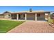 Green backyard area with artificial turf, gravel landscaping, and a covered patio at 3747 W Aire Libre Ave, Phoenix, AZ 85053