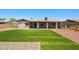 Lush backyard featuring green artificial turf, gravel landscaping, and a covered patio area at 3747 W Aire Libre Ave, Phoenix, AZ 85053