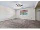 Bright, carpeted bedroom with a ceiling fan and natural light from a window at 3747 W Aire Libre Ave, Phoenix, AZ 85053