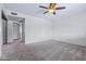 Carpeted bedroom featuring a ceiling fan, closet, and neutral-colored walls at 3747 W Aire Libre Ave, Phoenix, AZ 85053