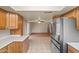 Inviting kitchen featuring light brown cabinets and stainless steel appliances open to the living area at 3747 W Aire Libre Ave, Phoenix, AZ 85053
