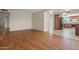 Spacious living room showcasing wood floors with kitchen in the background and natural light at 3747 W Aire Libre Ave, Phoenix, AZ 85053