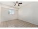 This bedroom features a ceiling fan and a window with bright, natural light and tile flooring at 3821 N 28Th St, Phoenix, AZ 85016