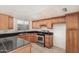 Traditional kitchen featuring wooden cabinets, black countertops, and stainless steel appliances at 3821 N 28Th St, Phoenix, AZ 85016