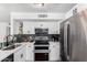 Updated kitchen featuring white cabinets with dark hardware, stainless appliances, and granite countertops at 3829 W Camino Del Rio --, Glendale, AZ 85310