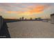 Wide backyard with gravel, and a gazebo against a sunset sky at 4088 N 309Th Cir, Buckeye, AZ 85396
