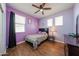 Bedroom with a ceiling fan, wood-look floors, and lavender-painted walls at 4088 N 309Th Cir, Buckeye, AZ 85396