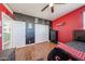Spacious bedroom with red accent wall, wood flooring, and closet at 4088 N 309Th Cir, Buckeye, AZ 85396