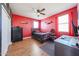 Red bedroom with ceiling fan, wooden desk, and a comfortable bed at 4088 N 309Th Cir, Buckeye, AZ 85396
