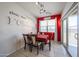 Stylish dining room with unique wall decor, a vibrant red accent wall, and a sliding glass door for outdoor access at 4088 N 309Th Cir, Buckeye, AZ 85396
