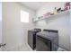 Clean laundry room with modern washer and dryer, plus shelving for storage at 4088 N 309Th Cir, Buckeye, AZ 85396
