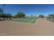 Outdoor tennis court with green surface, net, and lighting for evening play at 4088 N 309Th Cir, Buckeye, AZ 85396