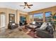 Cozy living room featuring tile flooring, comfortable leather seating, a ceiling fan, and a stone fireplace at 4821 E Kirkland Rd, Phoenix, AZ 85054