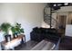 Living room featuring hardwood floors, a dark sofa, and a spiral staircase with wrought iron railings at 5720 S 21St Ter, Phoenix, AZ 85040