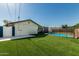 Backyard with a gated pool area, white fence, and grassy lawn at 591 N Cheri Lynn Dr, Chandler, AZ 85225