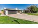 Single-story home features solar panels, a well-maintained lawn, and a two-car garage at 591 N Cheri Lynn Dr, Chandler, AZ 85225