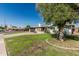 Charming single-story home with a well-kept lawn and a large shade tree at 591 N Cheri Lynn Dr, Chandler, AZ 85225