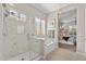 Well-lit bathroom with a walk-in shower, soaking tub, shuttered window and a connecting bedroom at 6948 E Quill St, Mesa, AZ 85207