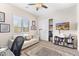 Bright bedroom with a white sofa, office desk, TV, and built-in shelves with decor at 6948 E Quill St, Mesa, AZ 85207