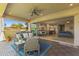 Inviting covered patio with dining, outdoor seating, ceiling fan, grill, and a seamless indoor-outdoor flow at 6948 E Quill St, Mesa, AZ 85207