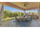 Relaxing covered patio featuring outdoor furniture, a grill, and lush landscaping overlooking the mountain at 6948 E Quill St, Mesa, AZ 85207