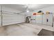 Well-organized two-car garage with ample storage cabinets and epoxy-coated flooring at 6948 E Quill St, Mesa, AZ 85207