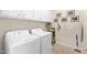 Bright laundry room featuring front load machines, tiled floor, and ample storage cabinets at 6948 E Quill St, Mesa, AZ 85207