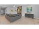 Comfortable living room featuring a sleek gray sofa, hardwood accent wall, and stylish decor at 6948 E Quill St, Mesa, AZ 85207