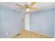 Light blue bedroom with ceiling fan, wood-look floors, white door, and wall-mounted outlets at 747 E Germann Rd # 15, San Tan Valley, AZ 85140