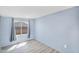 Bedroom with wood-look flooring, light blue accent wall, and window with gray drapes at 747 E Germann Rd # 15, San Tan Valley, AZ 85140