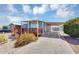Inviting single-story home featuring a covered porch, vibrant landscaping, and a practical carport for vehicle storage at 747 E Germann Rd # 15, San Tan Valley, AZ 85140