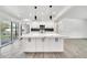 Open concept kitchen features white cabinetry, marble countertops, stainless appliances and modern pendant lights at 8436 N 13Th N Pl, Phoenix, AZ 85020