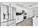 Contemporary kitchen with stainless steel refrigerator and appliances, sleek white cabinets, and marble-look backsplash at 8436 N 13Th N Pl, Phoenix, AZ 85020