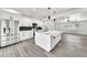 Open kitchen concept with a large island, stainless steel appliances, white cabinetry, and modern black hardware at 8436 N 13Th N Pl, Phoenix, AZ 85020