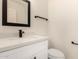 Modern half-bathroom with a stylish black framed mirror, modern vanity, and toilet at 8928 E Crescent Ave, Mesa, AZ 85208