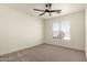 Bright bedroom with neutral carpet, a ceiling fan, and a window offering an outdoor view at 8928 E Crescent Ave, Mesa, AZ 85208