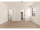 Bright, empty bedroom features modern wood-look floors, two doors, and natural light from the window at 8928 E Crescent Ave, Mesa, AZ 85208