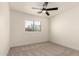 Bright bedroom with neutral carpet, a ceiling fan, and a window offering an outdoor view at 8928 E Crescent Ave, Mesa, AZ 85208