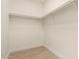 This walk-in closet features minimalist design and a sturdy clothing rod for optimal storage solutions at 8928 E Crescent Ave, Mesa, AZ 85208