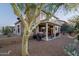 Charming backyard featuring a covered patio, desert landscaping, and an outdoor grill, ideal for relaxation and entertaining at 9548 E Kiva Ln, Gold Canyon, AZ 85118