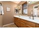 Bathroom with dual sinks, wood cabinets, and a large mirror with modern lighting at 9548 E Kiva Ln, Gold Canyon, AZ 85118