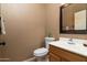 Cozy half bathroom with a wood vanity, a framed mirror, and neutral paint at 9548 E Kiva Ln, Gold Canyon, AZ 85118