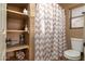 Bathroom with shower/tub combo, toilet, and organized shelving with cleaning supplies at 9548 E Kiva Ln, Gold Canyon, AZ 85118