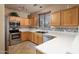 Modern kitchen with white countertops, wood cabinets, stainless steel appliances, and decorative backsplash at 9548 E Kiva Ln, Gold Canyon, AZ 85118