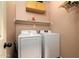 Functional laundry room with washer, dryer, storage shelves and neutral paint at 9548 E Kiva Ln, Gold Canyon, AZ 85118