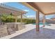 Outdoor kitchen with stone bar top, covered patio, and inviting pool creates an ideal backyard oasis at 10158 W Angels Ln, Peoria, AZ 85383
